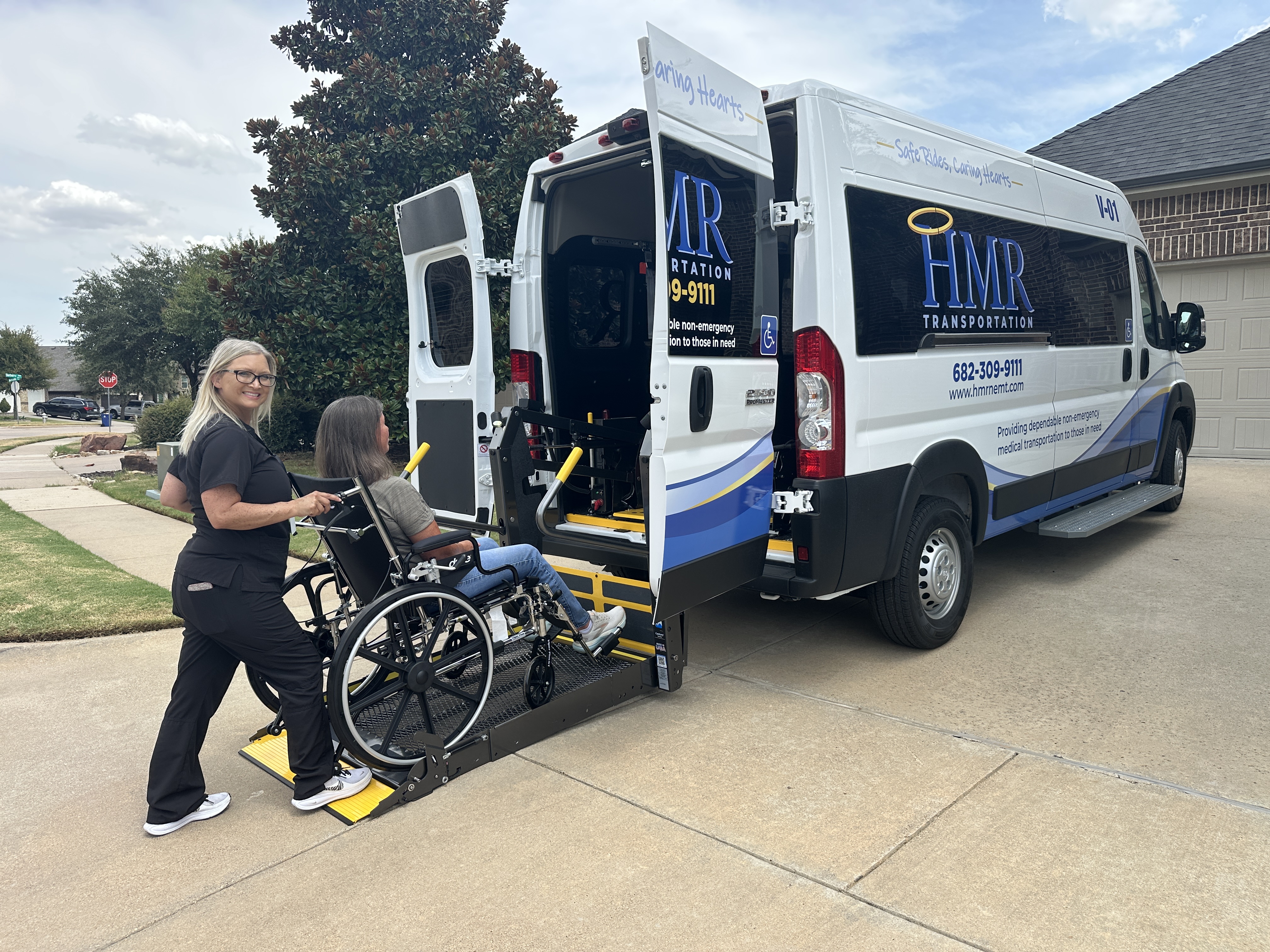 HMR team member assisting a passenger using a wheelchair into an HMR transportation vehicle
